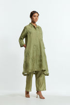 Green silk organza A-line short kurta featuring appliqué bird motifs gracefully placed across the front, back and sleeves. Paired with Green silk straight pants detailed with scalloped organza edging at the hem, delicately highlighted with tonal beadwork.