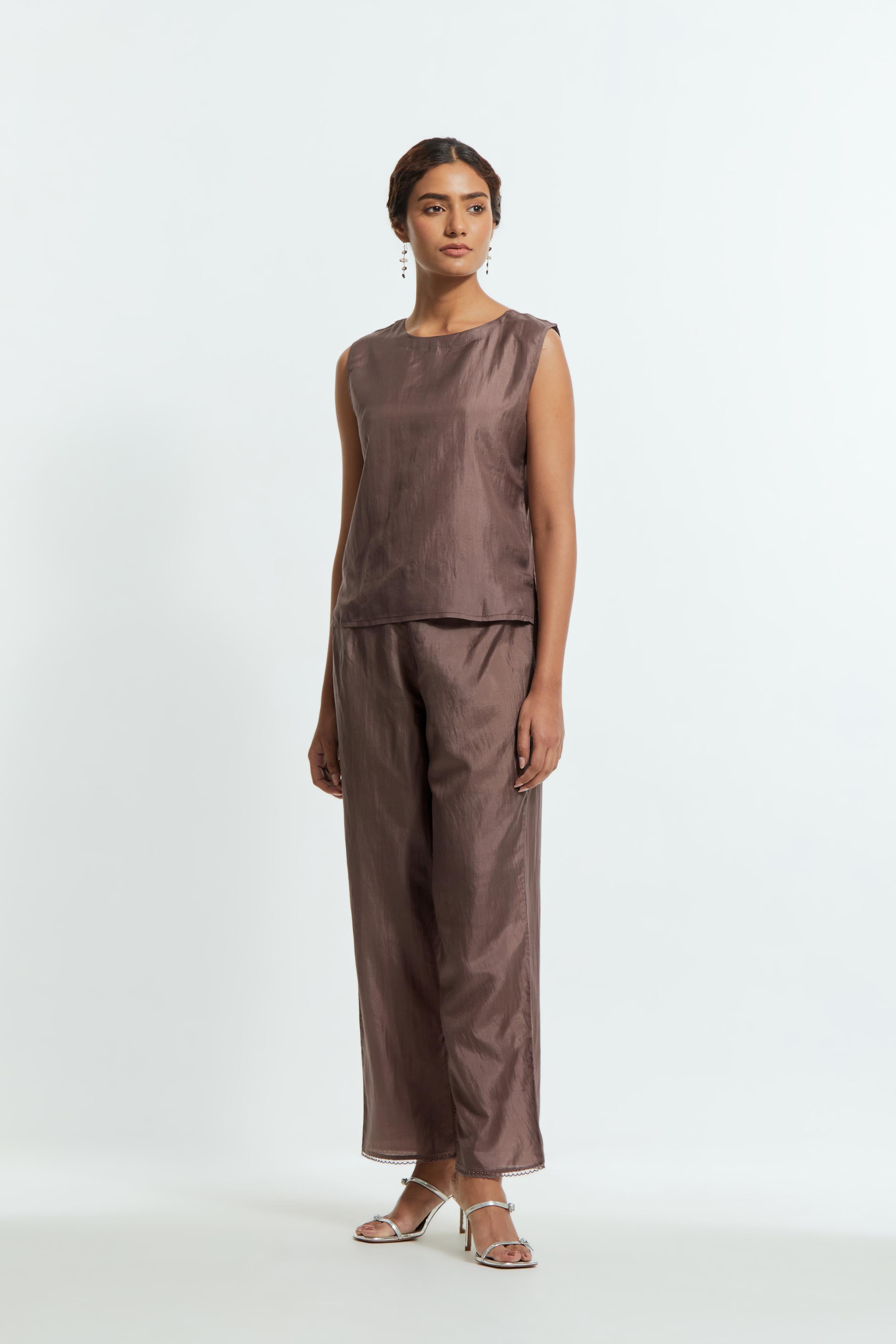 Grey silk organza kaftan with a sheer finish, delicately adorned with appliqué bird motifs along the hem and sides. Paired with Grey silk straight pants detailed with scalloped organza edging at the hem, delicately highlighted with tonal beadwork.
