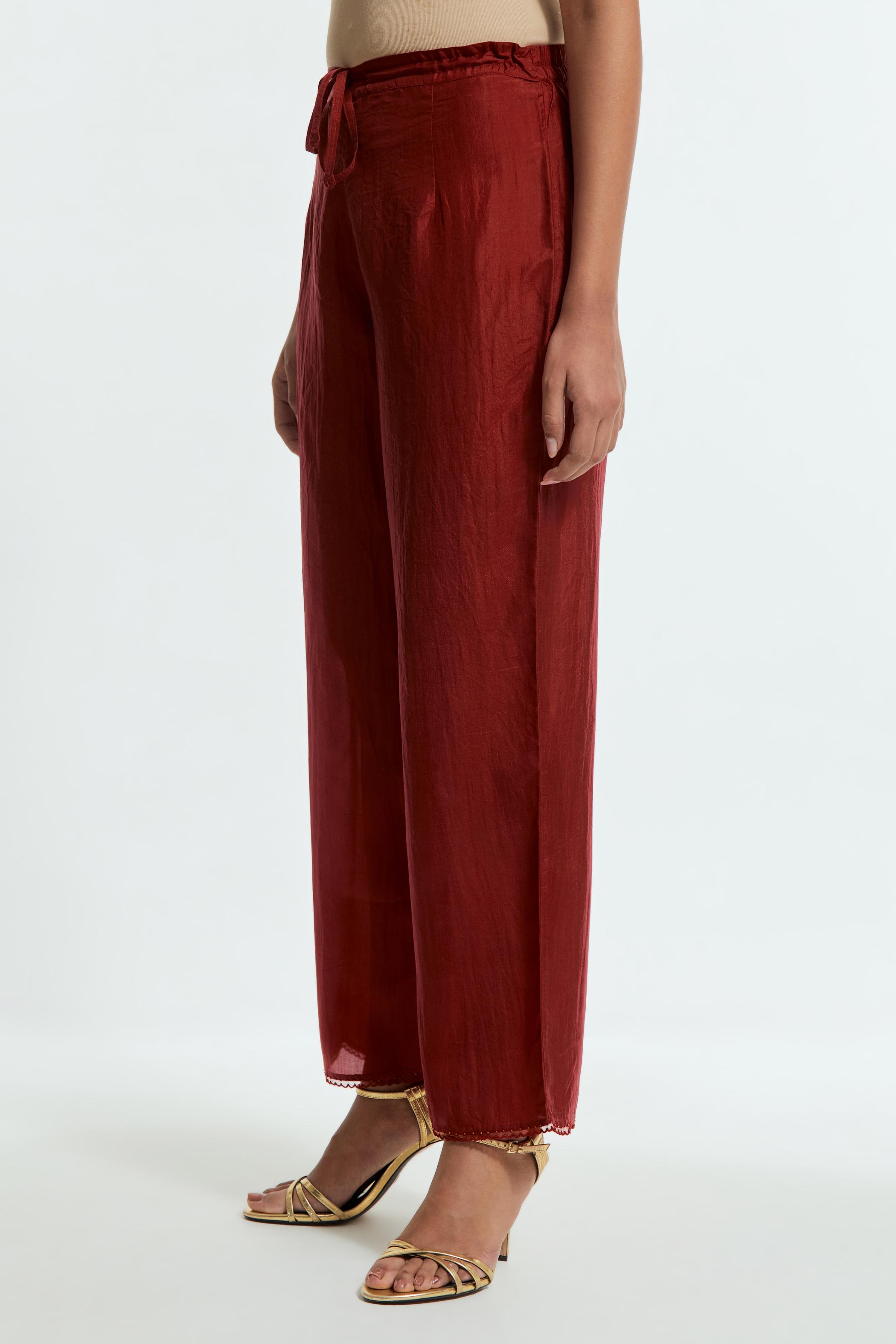 Red silk straight pants detailed with scalloped organza edging at the hem, delicately highlighted with tonal beadwork.