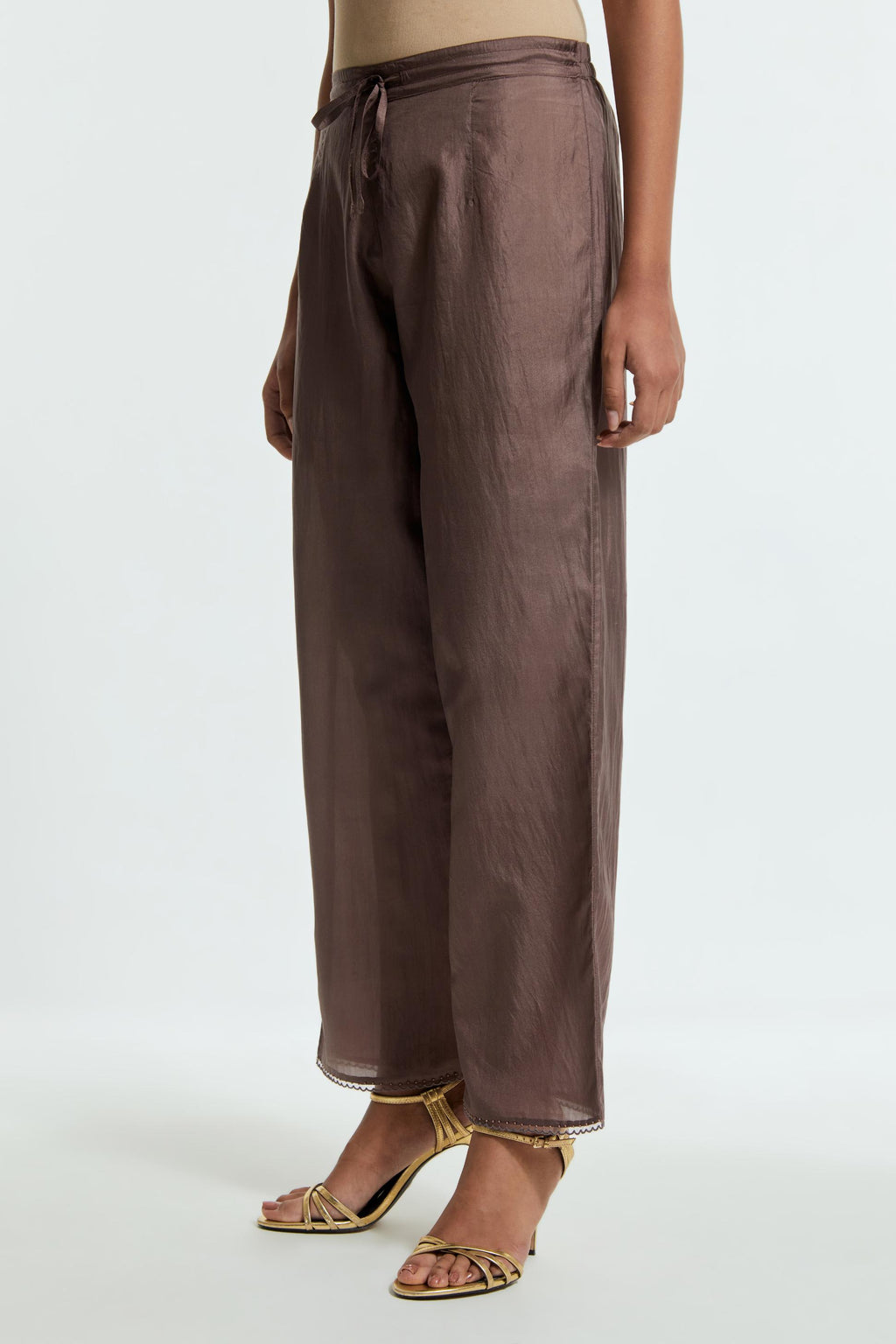 Grey silk straight pants detailed with scalloped organza edging at the hem, delicately highlighted with tonal beadwork.