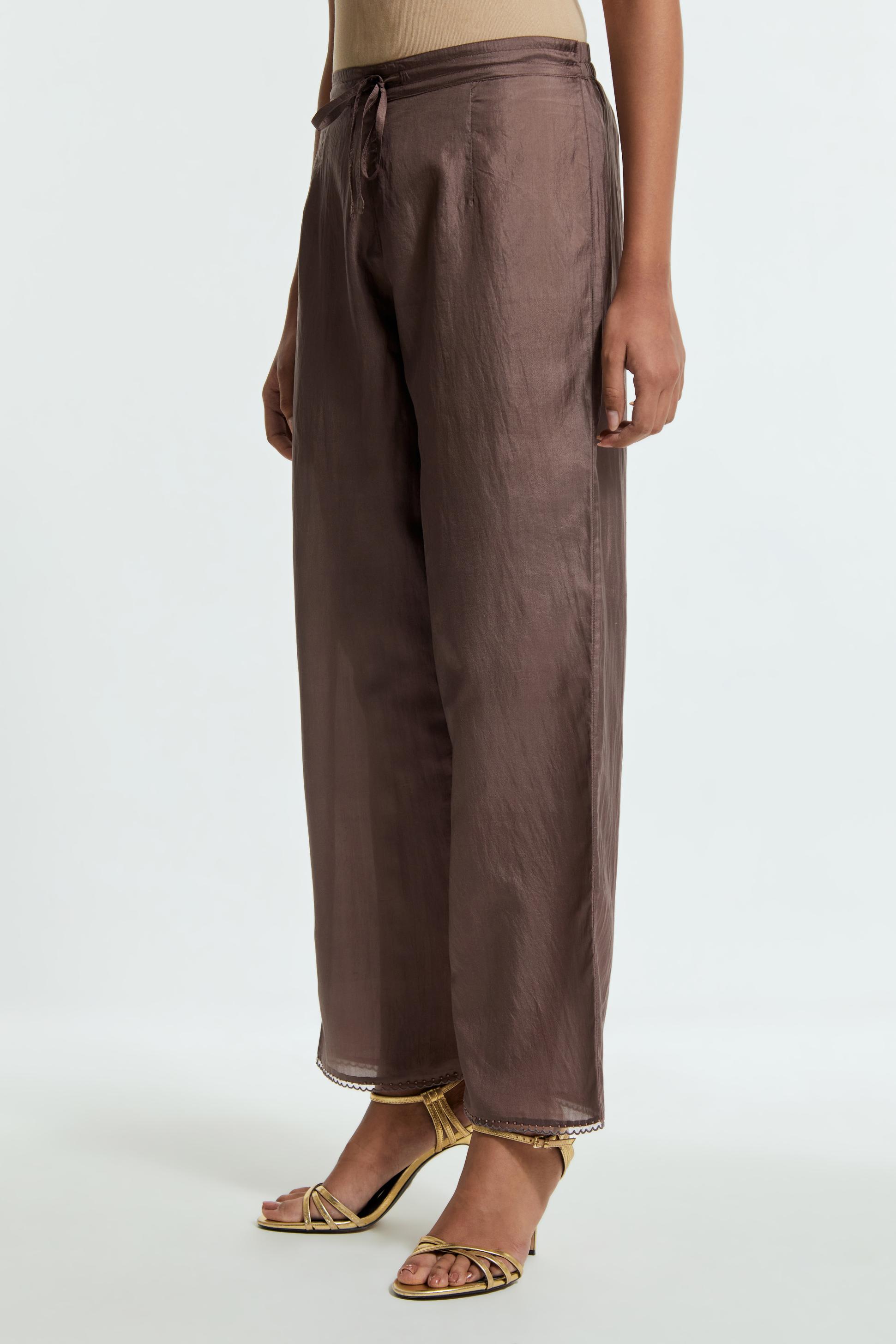 Grey silk straight pants detailed with scalloped organza edging at the hem, delicately highlighted with tonal beadwork.