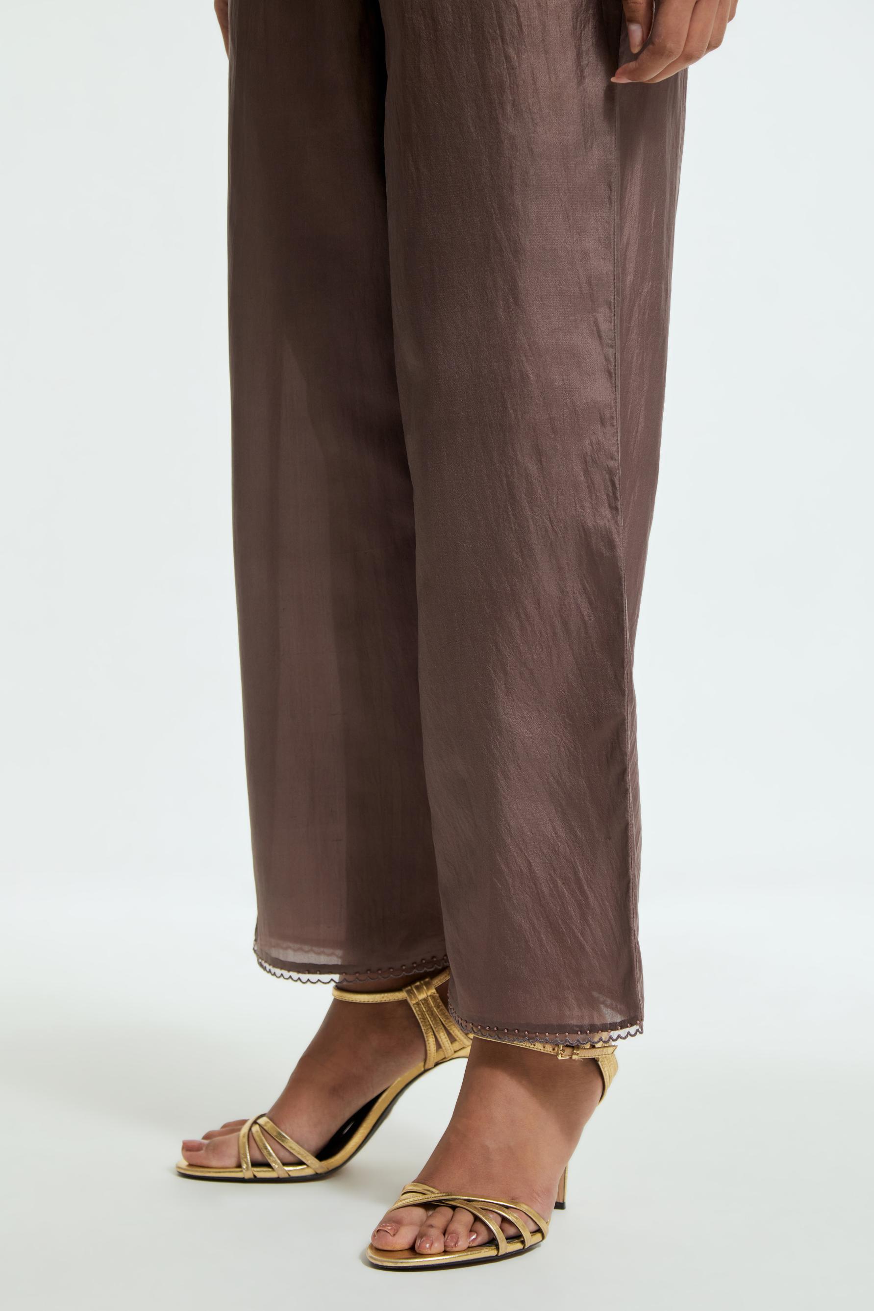 Grey silk straight pants detailed with scalloped organza edging at the hem, delicately highlighted with tonal beadwork.