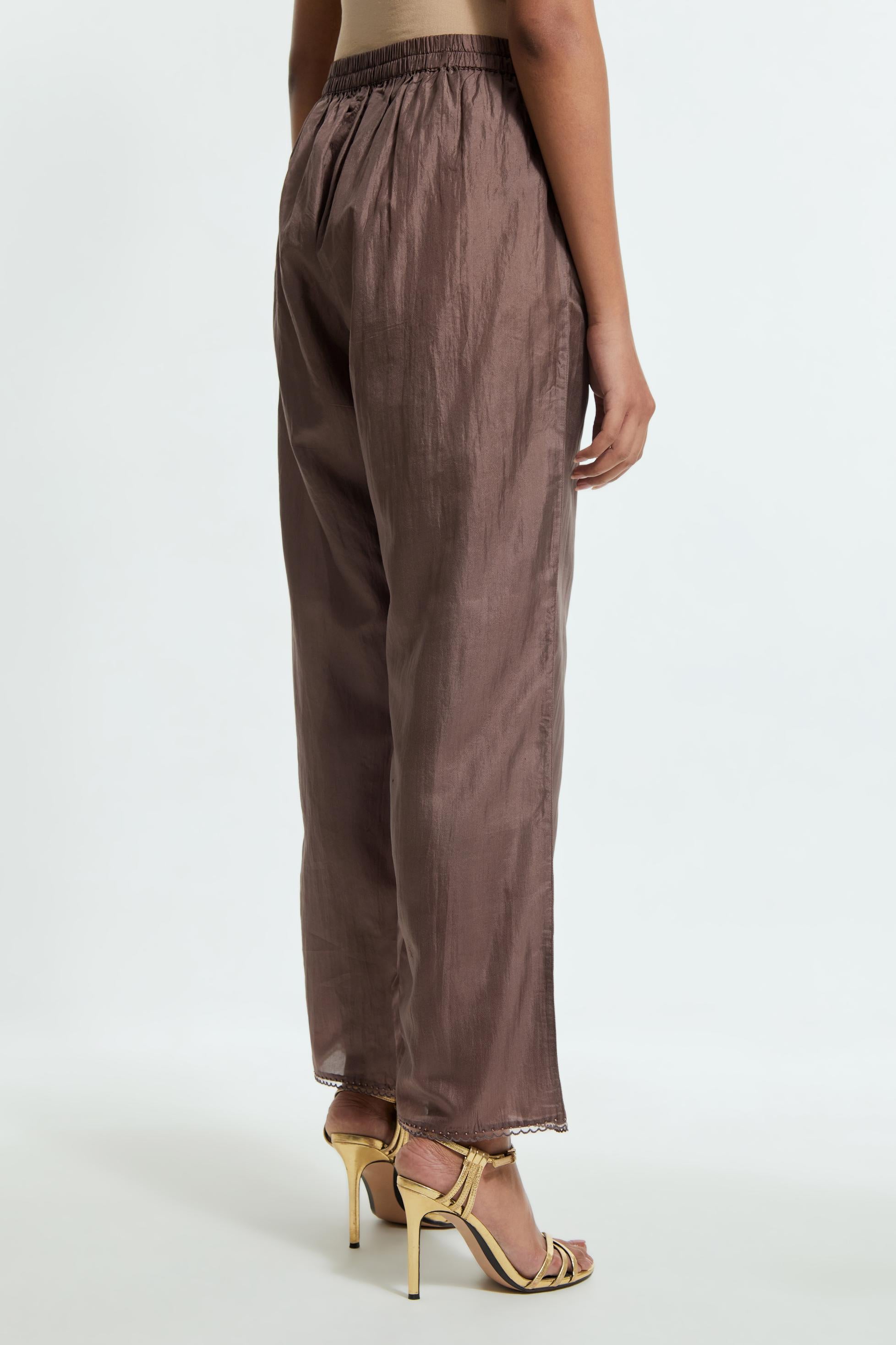 Grey silk straight pants detailed with scalloped organza edging at the hem, delicately highlighted with tonal beadwork.