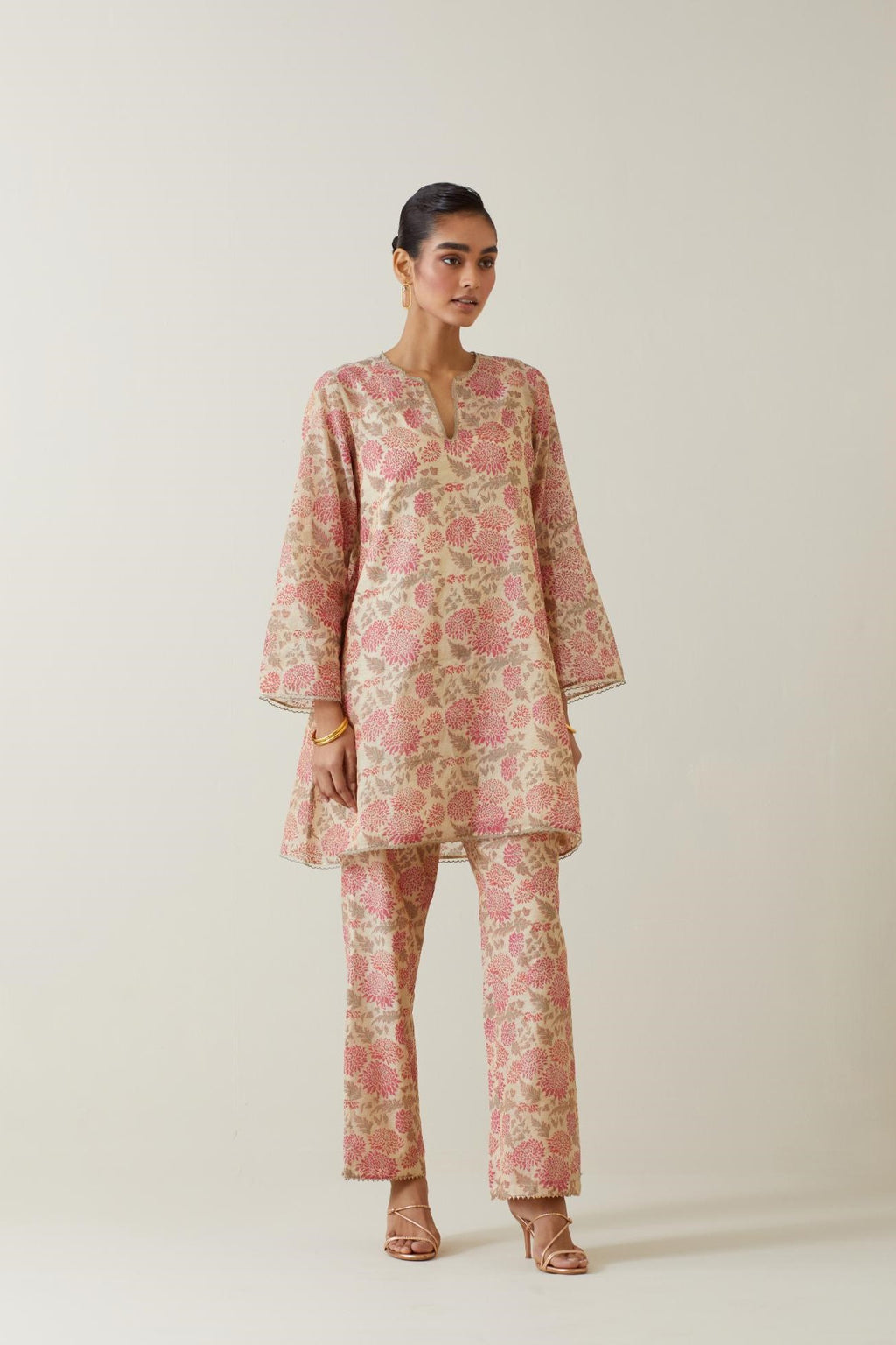 Beige tissue chanderi hand block printed easy fit short kurta, highlighted with scalloped organza at edges, paired with beige tissue chanderi all-over floral hand block printed straight pants.
