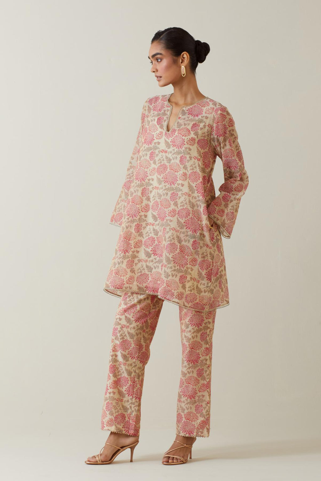 Beige tissue chanderi hand block printed easy fit short kurta, highlighted with scalloped organza at edges, paired with beige tissue chanderi all-over floral hand block printed straight pants.