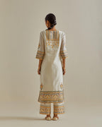 Yellow and off-white cotton chanderi straight kurta set with yoke with patchwork and silk thread embroidery highlighted with mirror, sequins, tassels and braids.