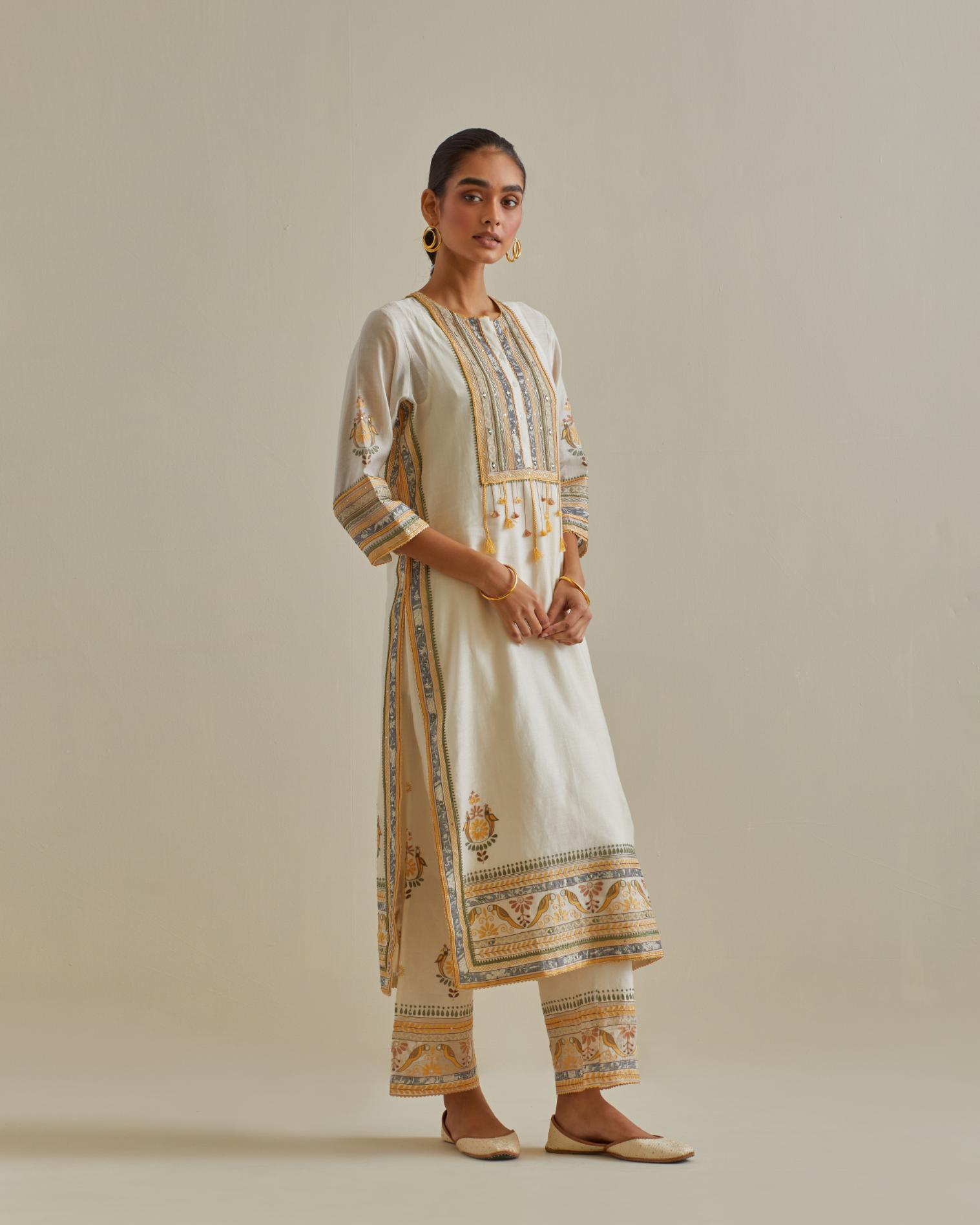 Yellow and off-white cotton chanderi straight kurta set with yoke with patchwork and silk thread embroidery highlighted with mirror, sequins, tassels and braids.