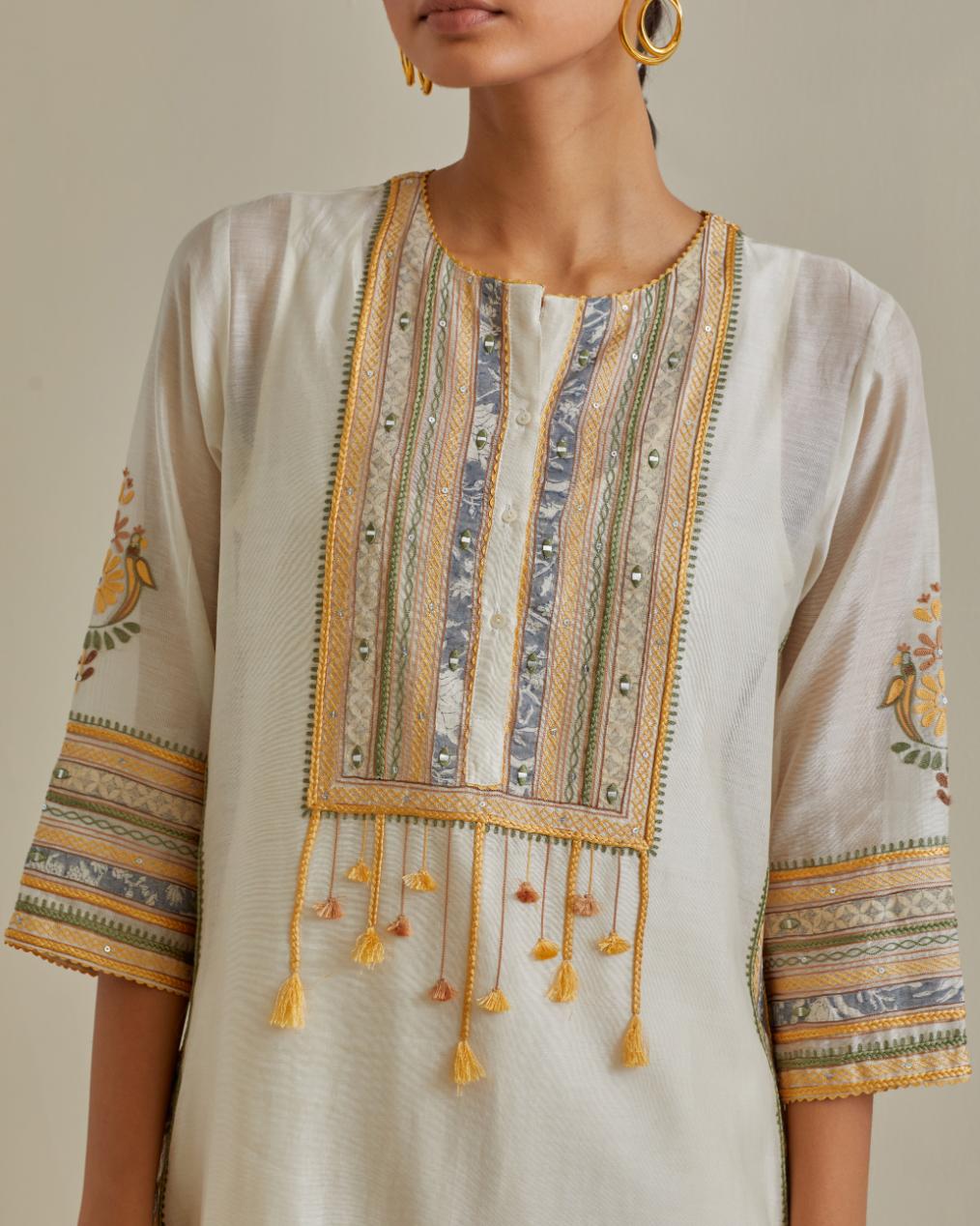 Yellow and off-white cotton chanderi straight kurta set with yoke with patchwork and silk thread embroidery highlighted with mirror, sequins, tassels and braids.
