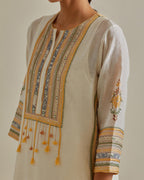 Yellow and off-white cotton chanderi straight kurta set with yoke with patchwork and silk thread embroidery highlighted with mirror, sequins, tassels and braids.