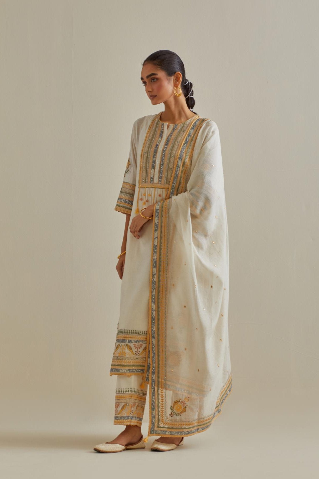 Yellow and off-white cotton chanderi straight kurta set with yoke with patchwork and silk thread embroidery highlighted with mirror, sequins, tassels and braids.