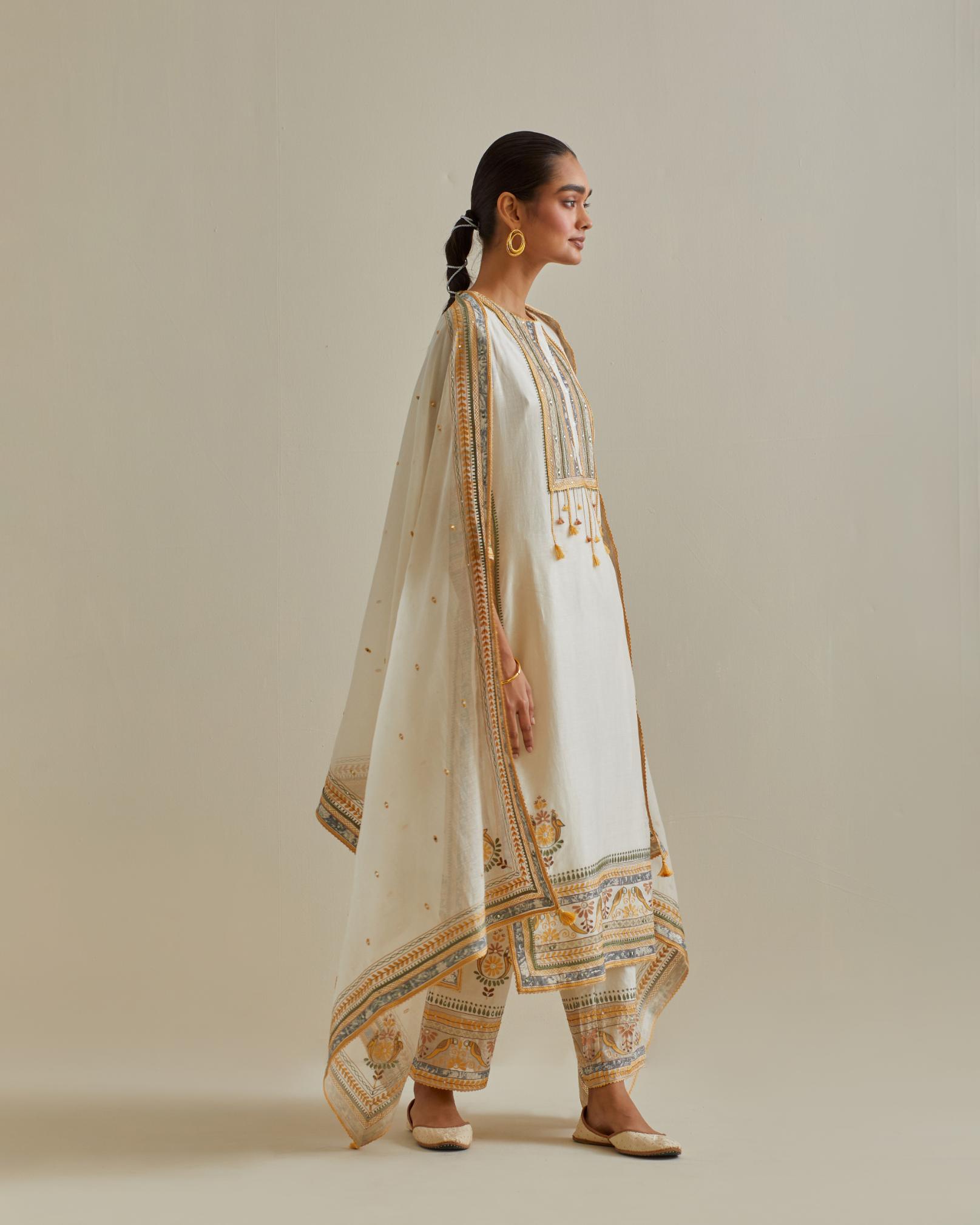 Yellow and off-white cotton chanderi straight kurta set with yoke with patchwork and silk thread embroidery highlighted with mirror, sequins, tassels and braids.