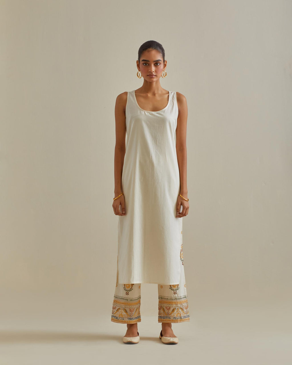 Yellow and off-white cotton chanderi straight kurta set with yoke and side panels. It has allover patchwork and silk thread embroidery, highlighted with mirror, sequins, tassels and braids.