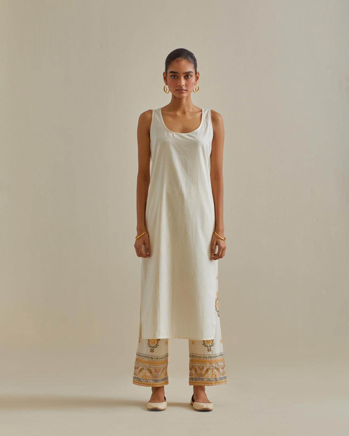 Yellow and off-white cotton chanderi straight kurta set with yoke and side panels. It has allover patchwork and silk thread embroidery, highlighted with mirror, sequins, tassels and braids.