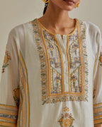 Yellow and off-white cotton chanderi straight kurta set with yoke and side panels. It has allover patchwork and silk thread embroidery, highlighted with mirror, sequins, tassels and braids.