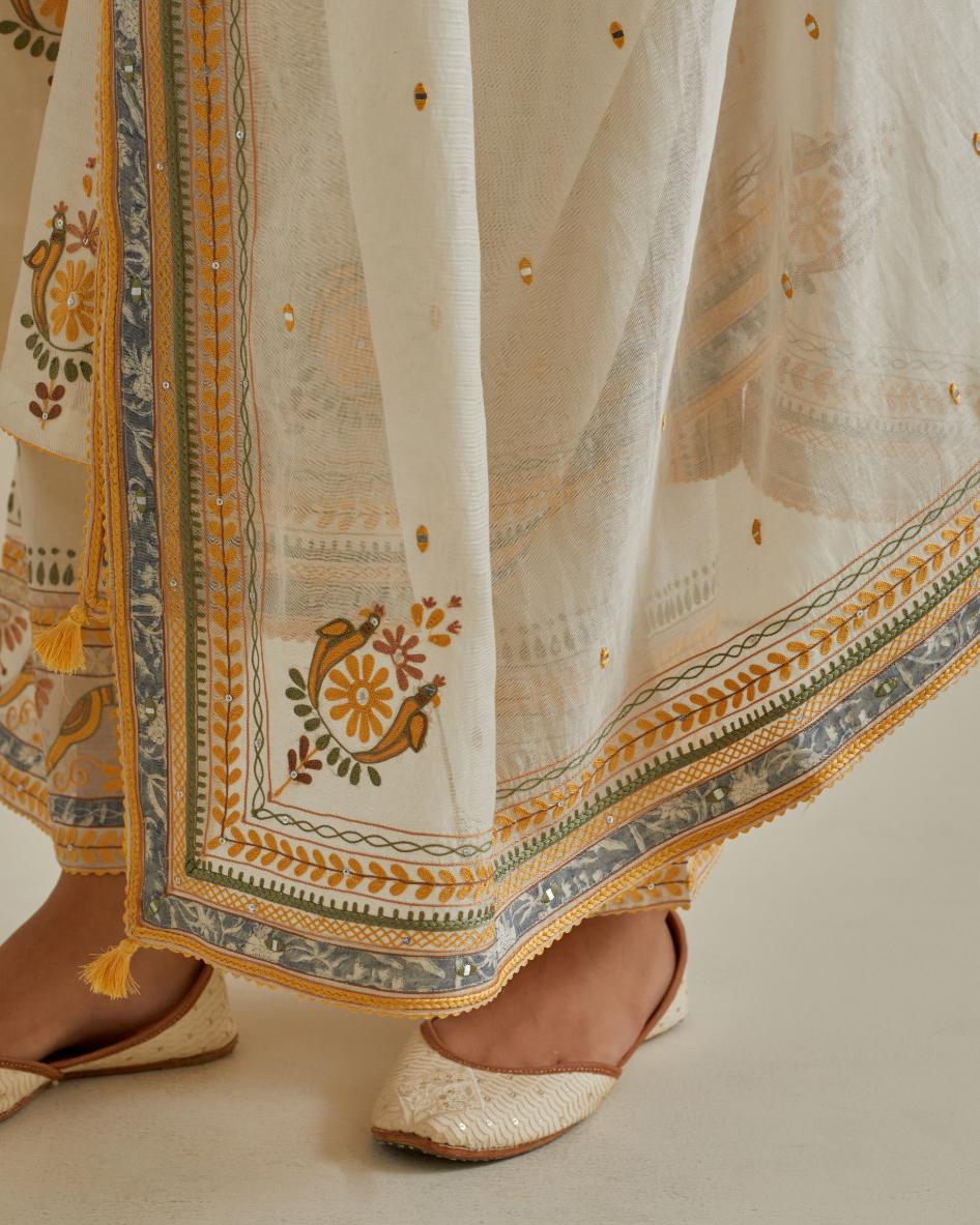 Yellow and off-white cotton chanderi straight kurta set with yoke and side panels. It has allover patchwork and silk thread embroidery, highlighted with mirror, sequins, tassels and braids.