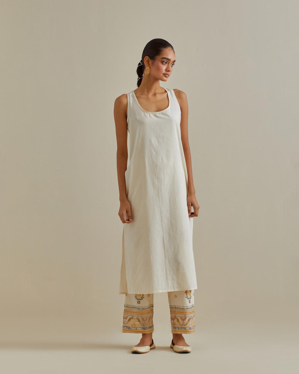 Yellow and off-white cotton chanderi straight kurta set with patchwork and thread embroidery highlighted with mirrors, sequins, tassels and braids.