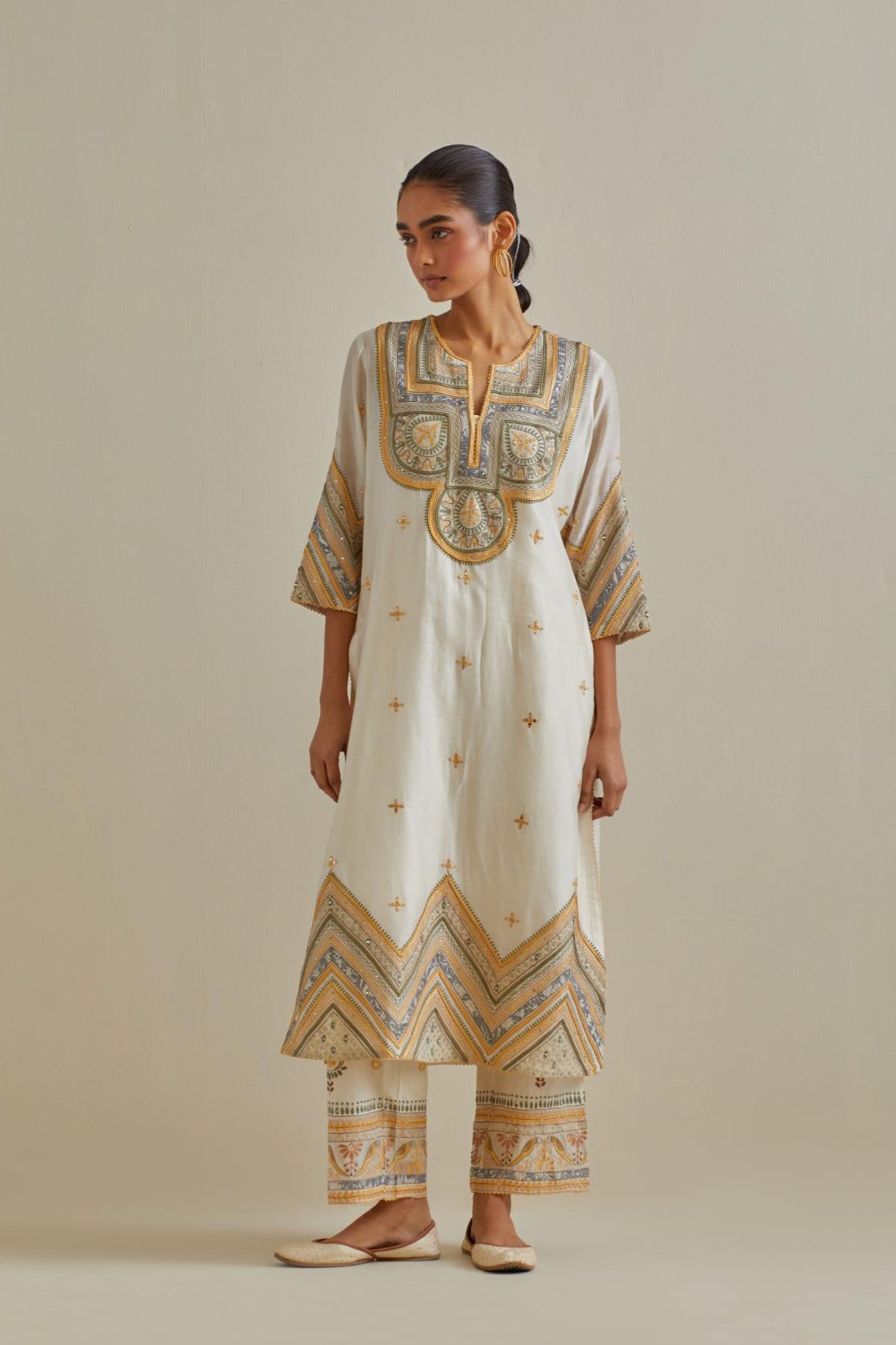 Yellow and off-white cotton chanderi straight kurta set with patchwork and thread embroidery highlighted with mirrors, sequins, tassels and braids.