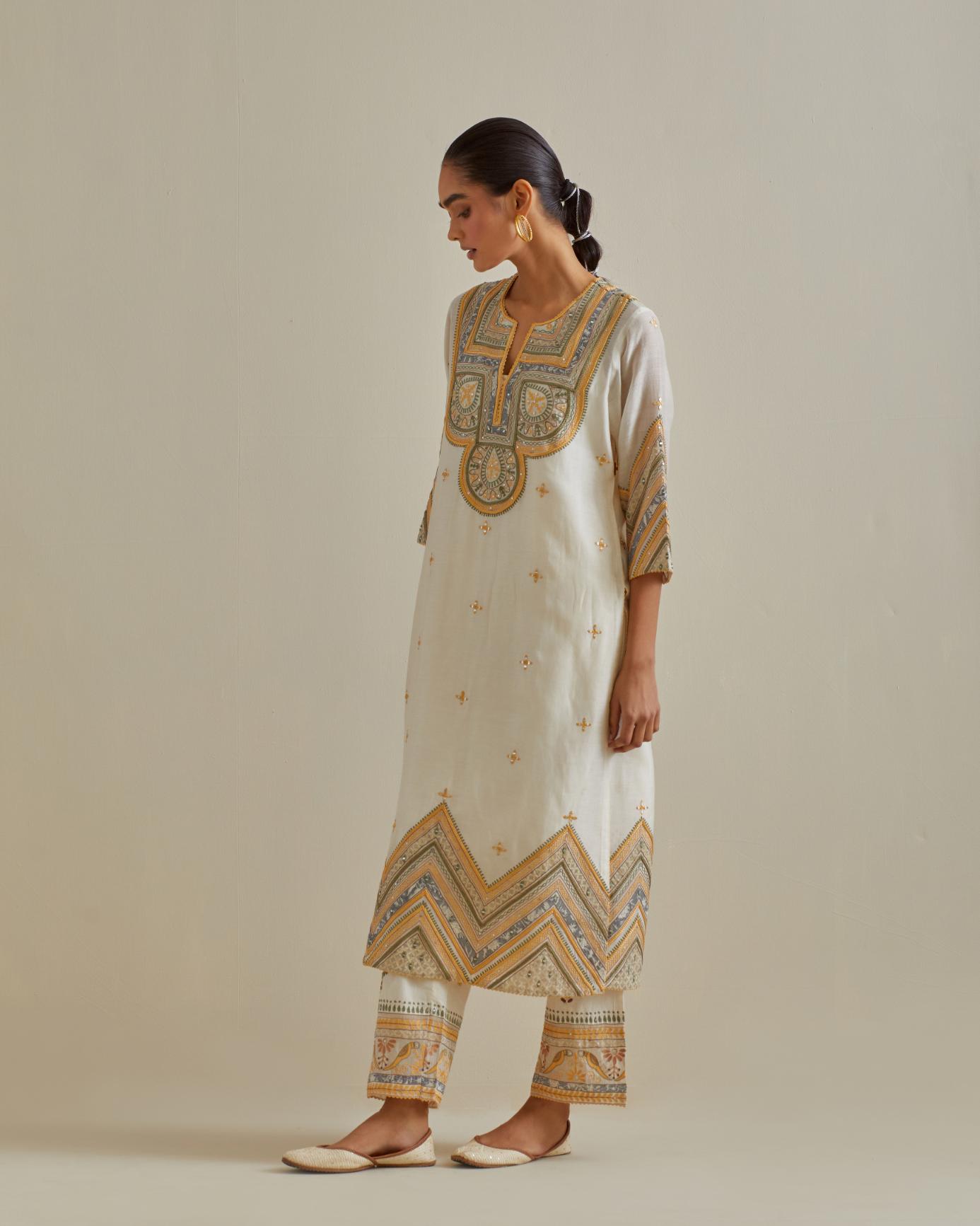 Yellow and off-white cotton chanderi straight kurta set with patchwork and thread embroidery highlighted with mirrors, sequins, tassels and braids.
