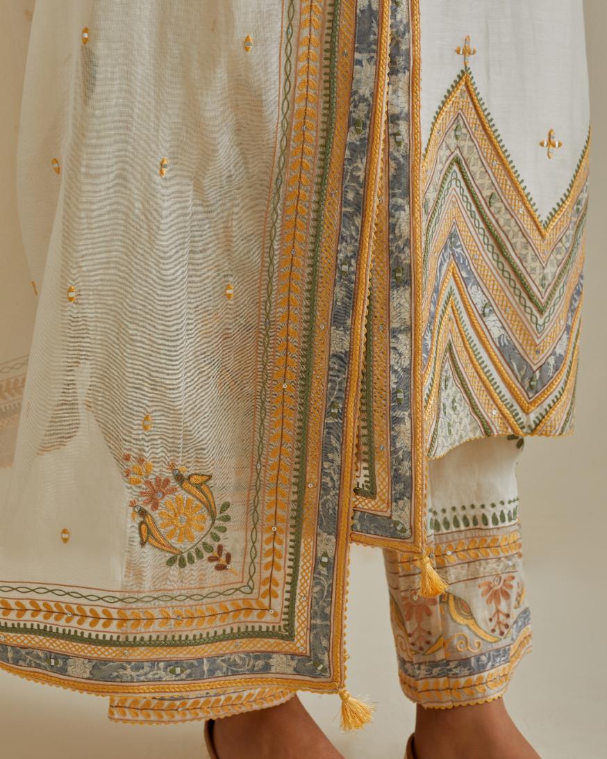 Yellow and off-white cotton chanderi straight kurta set with patchwork and thread embroidery highlighted with mirrors, sequins, tassels and braids.
