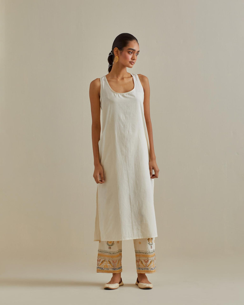 Yellow and off-white cotton chanderi straight kurta set with yoke with patchwork and silk thread embroidery highlighted with mirror, sequins, tassels and braids.