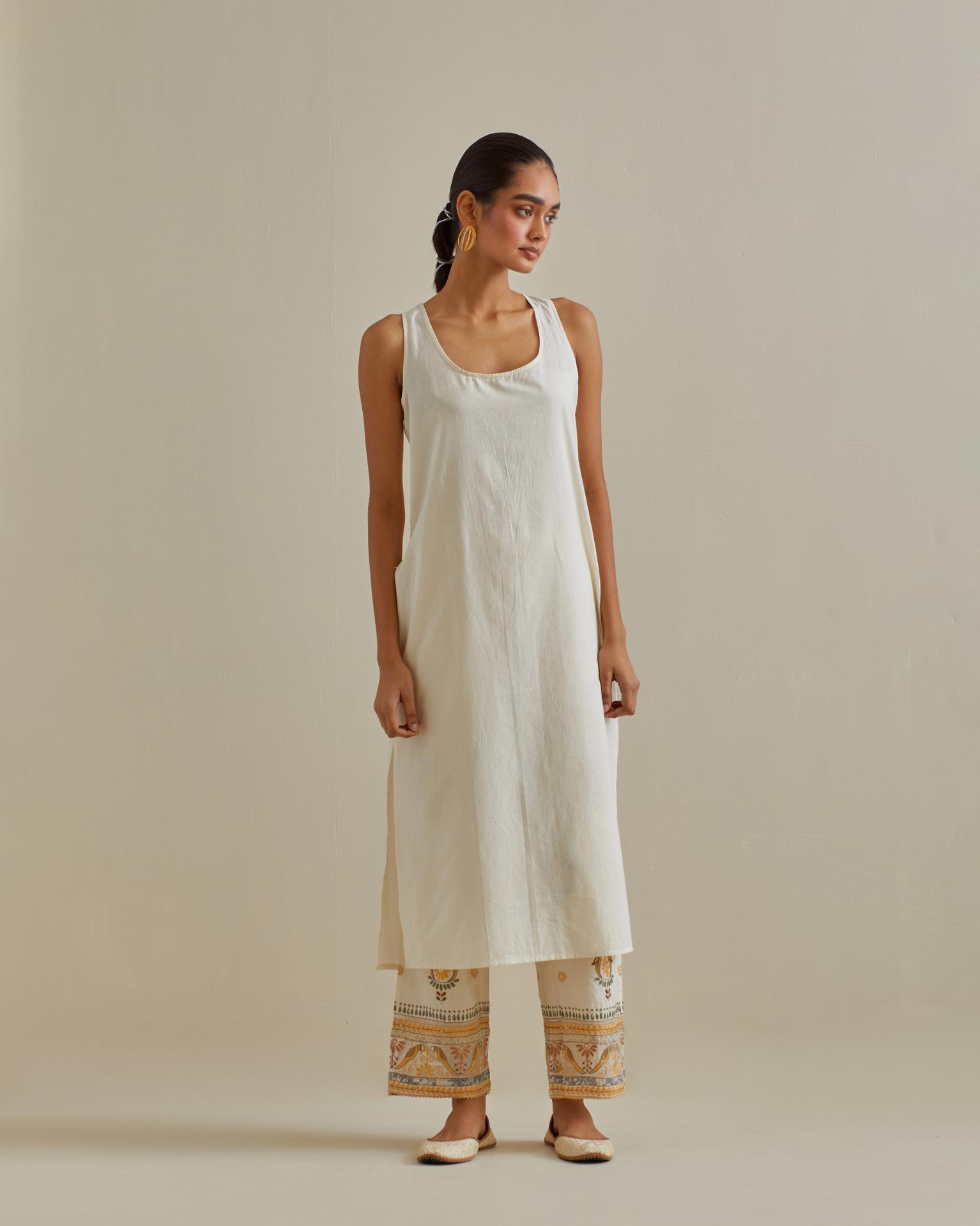 Yellow and off-white cotton chanderi straight kurta set with yoke with patchwork and silk thread embroidery highlighted with mirror, sequins, tassels and braids.