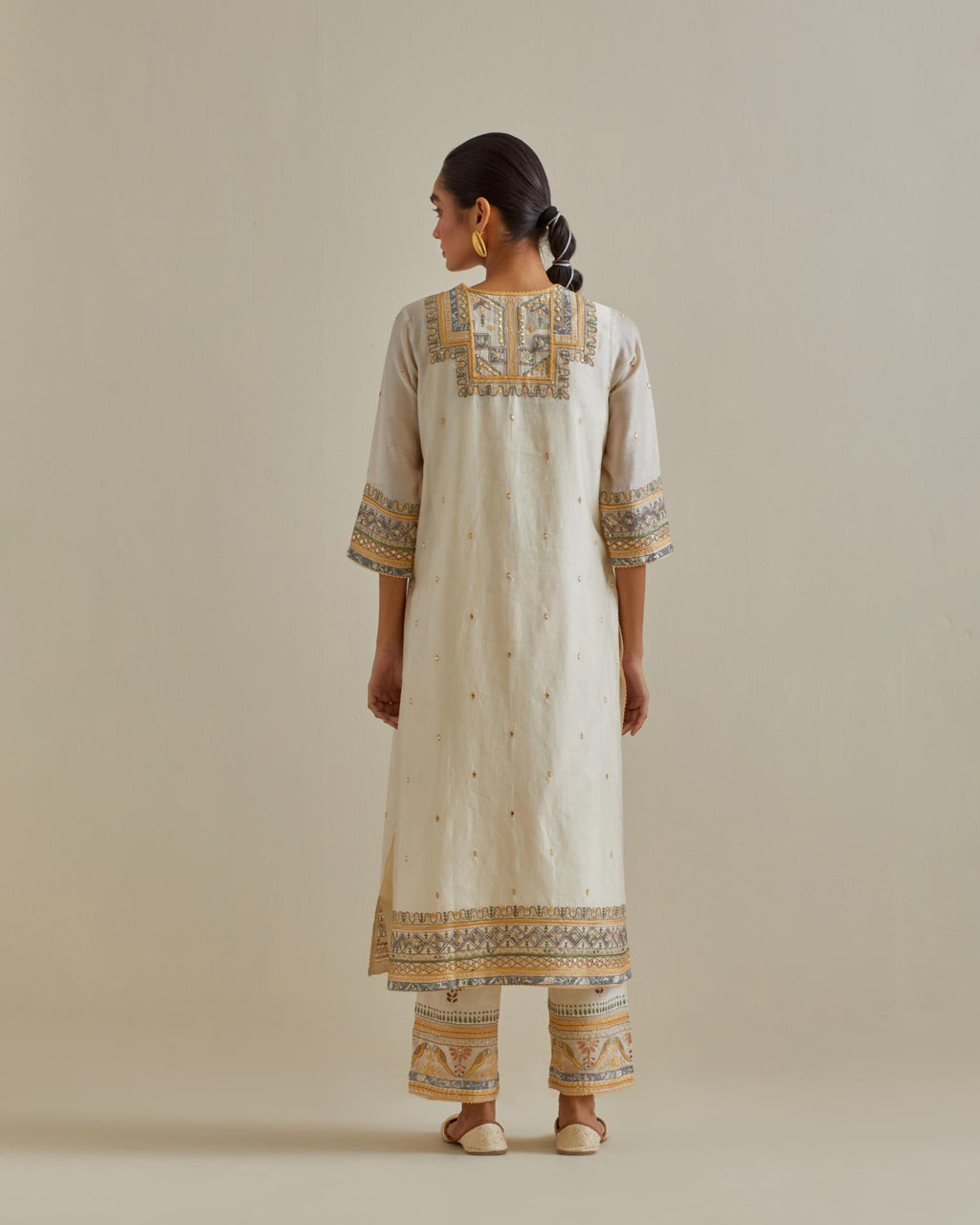 Yellow and off-white cotton chanderi straight kurta set with yoke with patchwork and silk thread embroidery highlighted with mirror, sequins, tassels and braids.