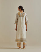 Yellow and off-white cotton chanderi straight kurta set with yoke with patchwork and silk thread embroidery highlighted with mirror, sequins, tassels and braids.