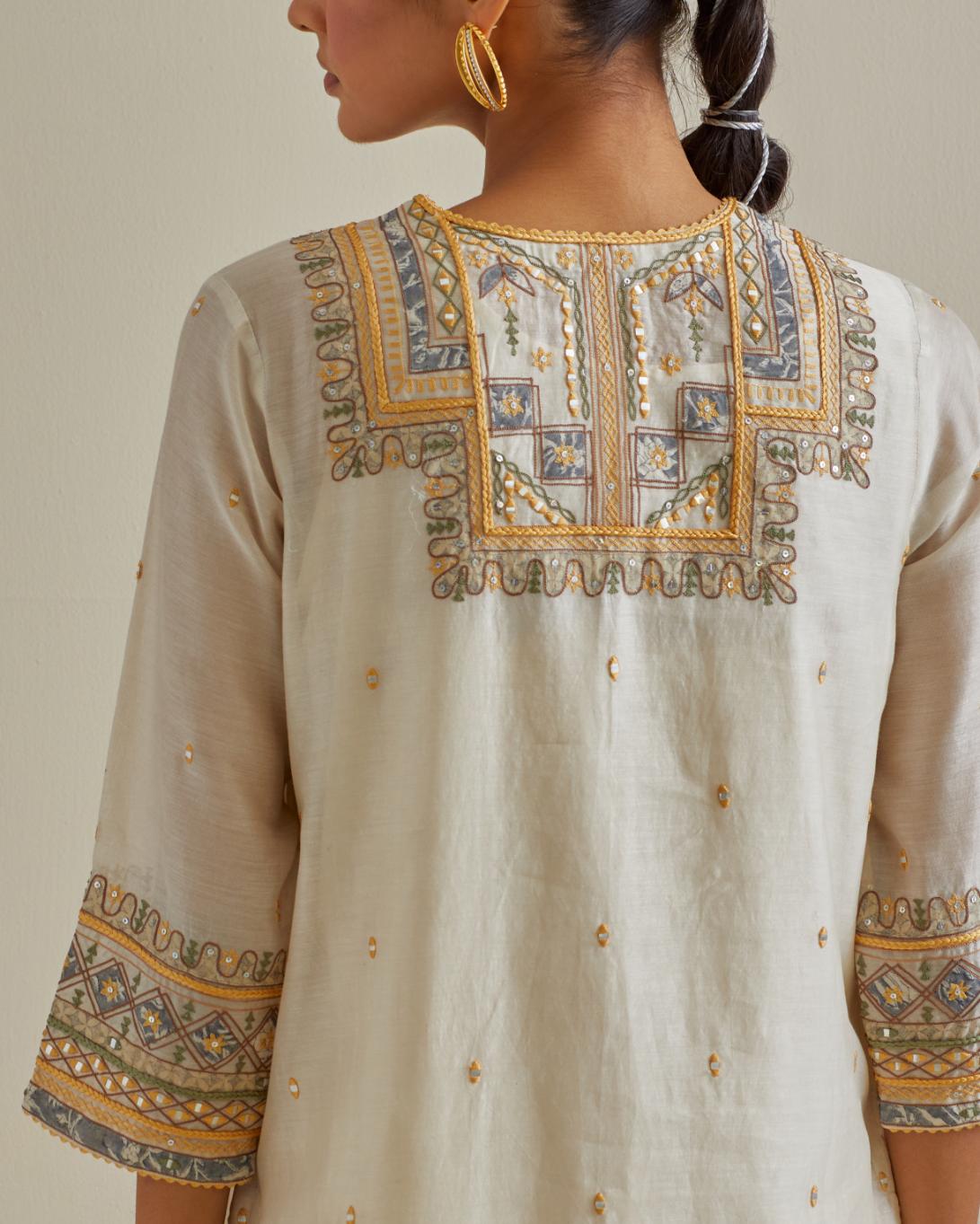 Yellow and off-white cotton chanderi straight kurta set with yoke with patchwork and silk thread embroidery highlighted with mirror, sequins, tassels and braids.