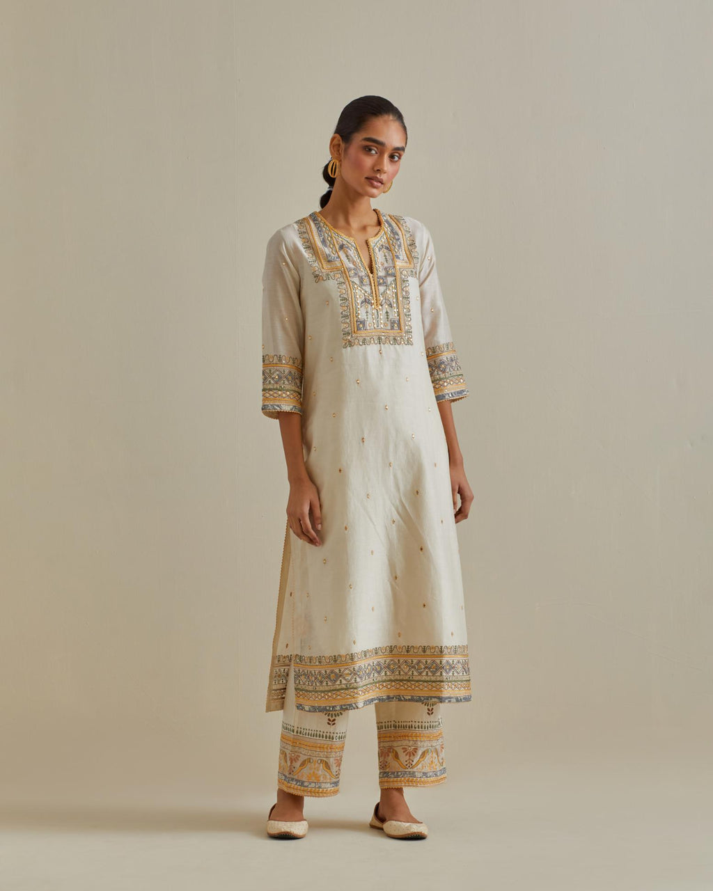 Yellow and off-white cotton chanderi straight kurta set with yoke with patchwork and silk thread embroidery highlighted with mirror, sequins, tassels and braids.