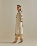 Yellow and off-white cotton chanderi straight kurta set with yoke with patchwork and silk thread embroidery highlighted with mirror, sequins, tassels and braids.