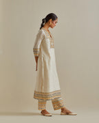 Yellow and off-white cotton chanderi straight kurta set with yoke with patchwork and silk thread embroidery highlighted with mirror, sequins, tassels and braids.