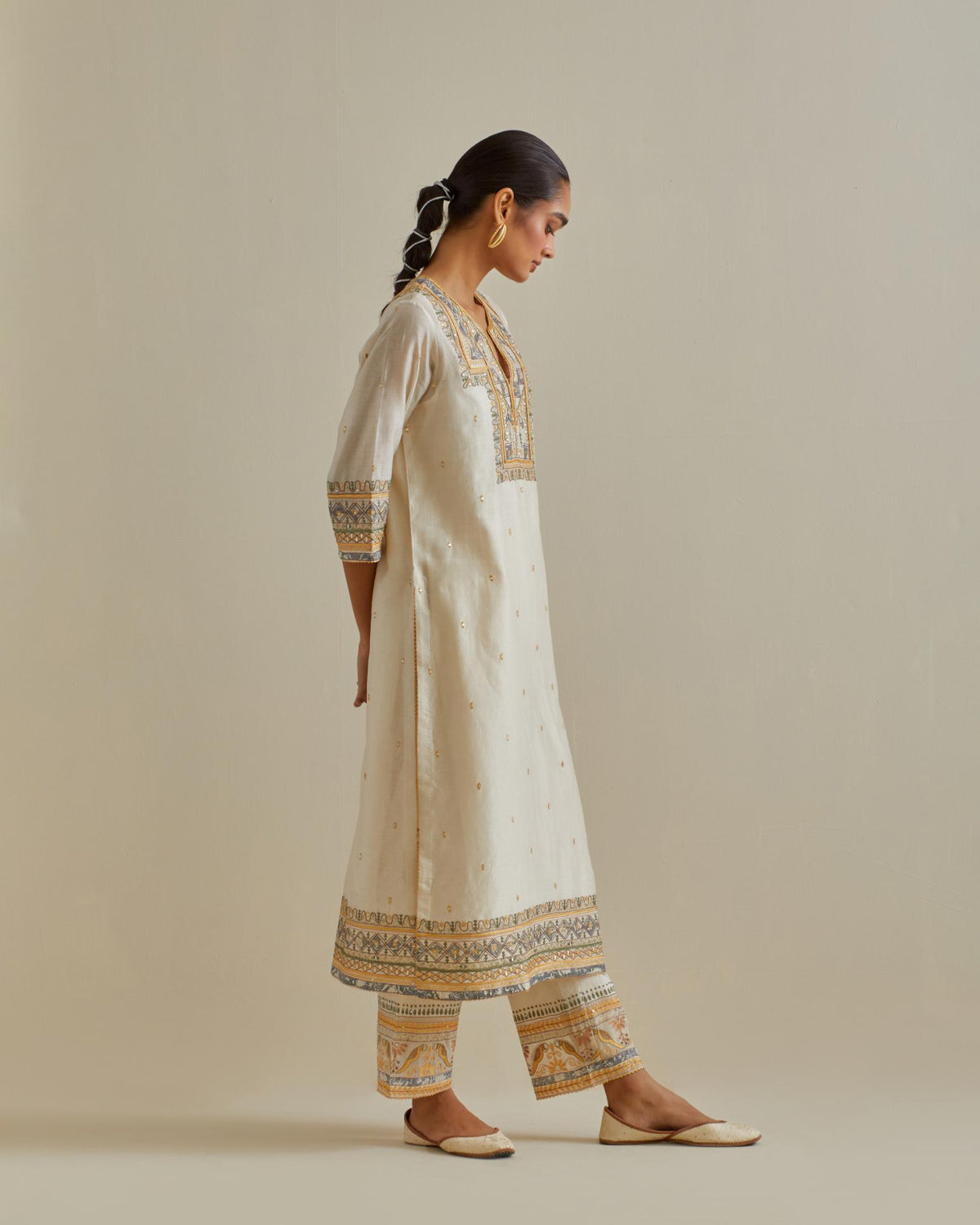 Yellow and off-white cotton chanderi straight kurta set with yoke with patchwork and silk thread embroidery highlighted with mirror, sequins, tassels and braids.