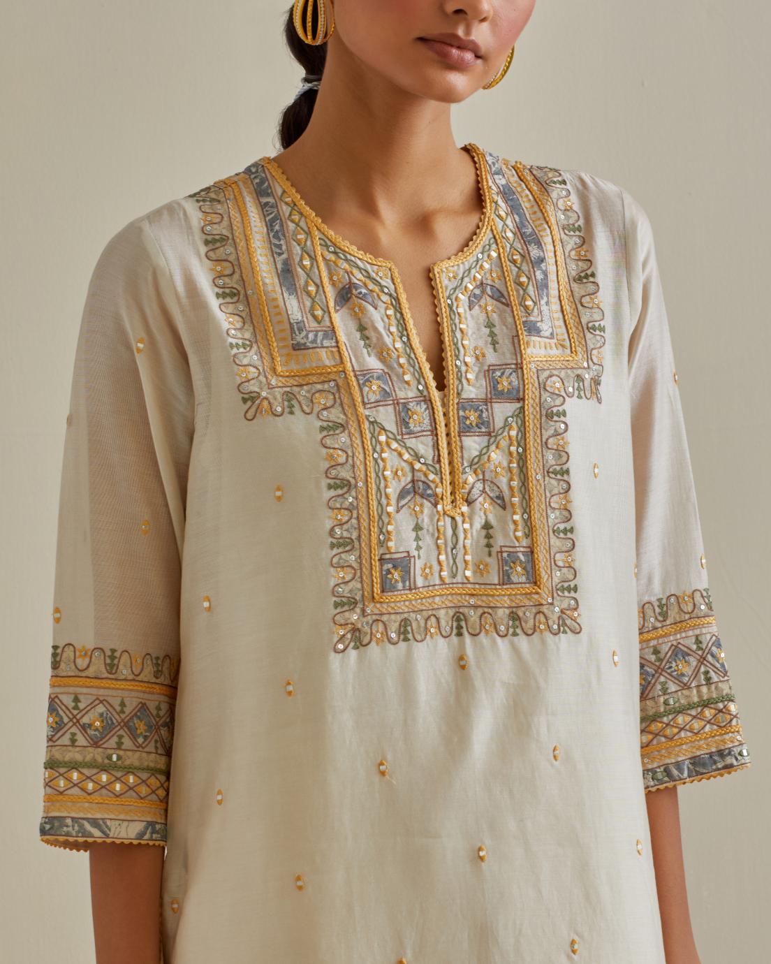 Yellow and off-white cotton chanderi straight kurta set with yoke with patchwork and silk thread embroidery highlighted with mirror, sequins, tassels and braids.