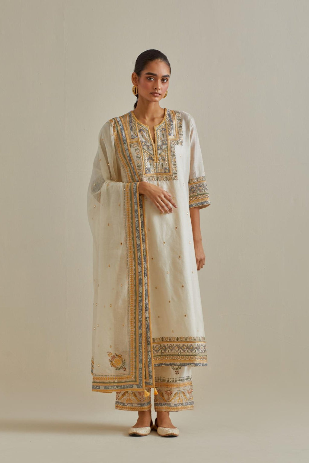 Yellow and off-white cotton chanderi straight kurta set with yoke with patchwork and silk thread embroidery highlighted with mirror, sequins, tassels and braids.