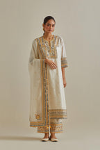 Yellow and off-white cotton chanderi straight kurta set with yoke with patchwork and silk thread embroidery highlighted with mirror, sequins, tassels and braids.