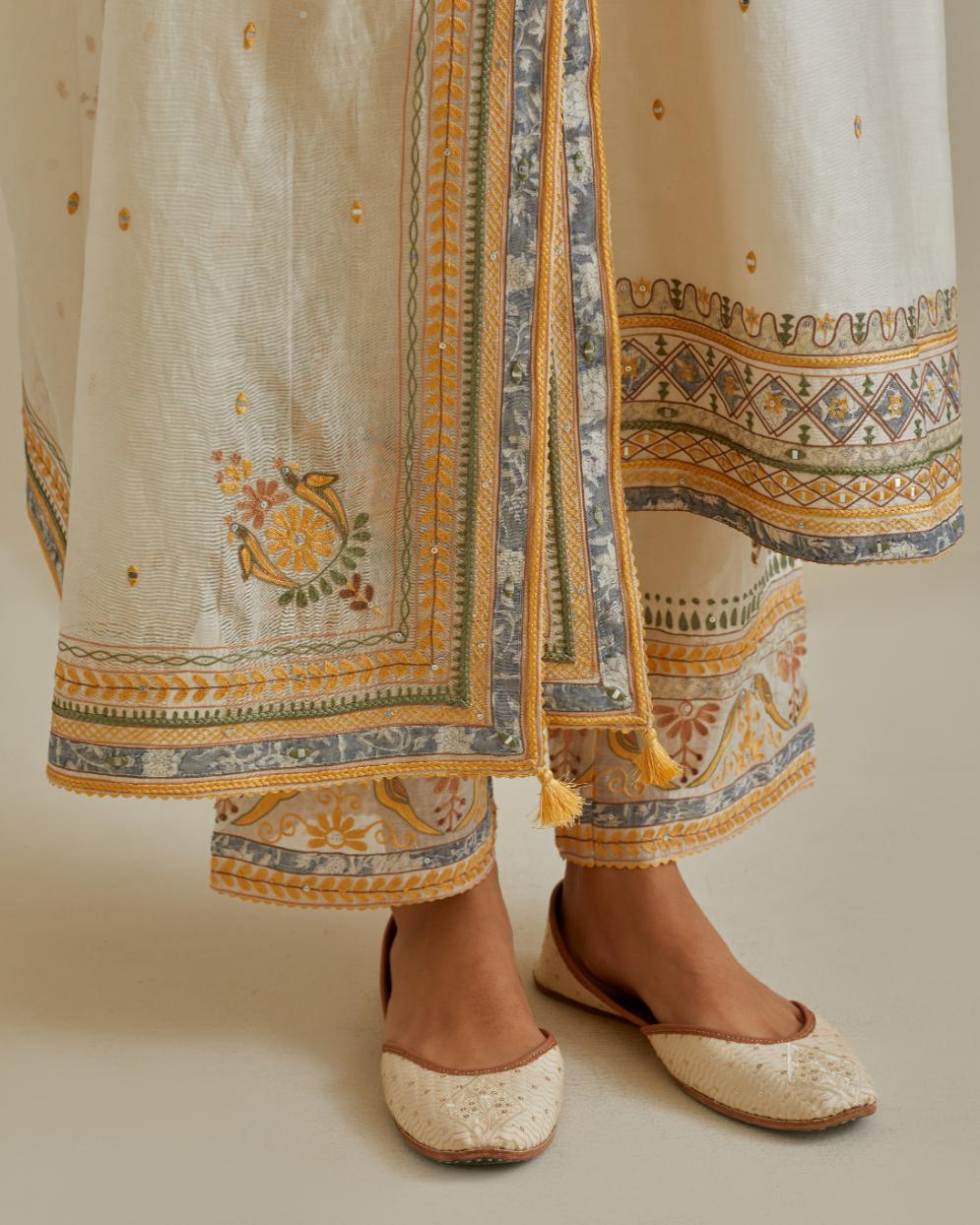 Yellow and off-white cotton chanderi straight kurta set with yoke with patchwork and silk thread embroidery highlighted with mirror, sequins, tassels and braids.