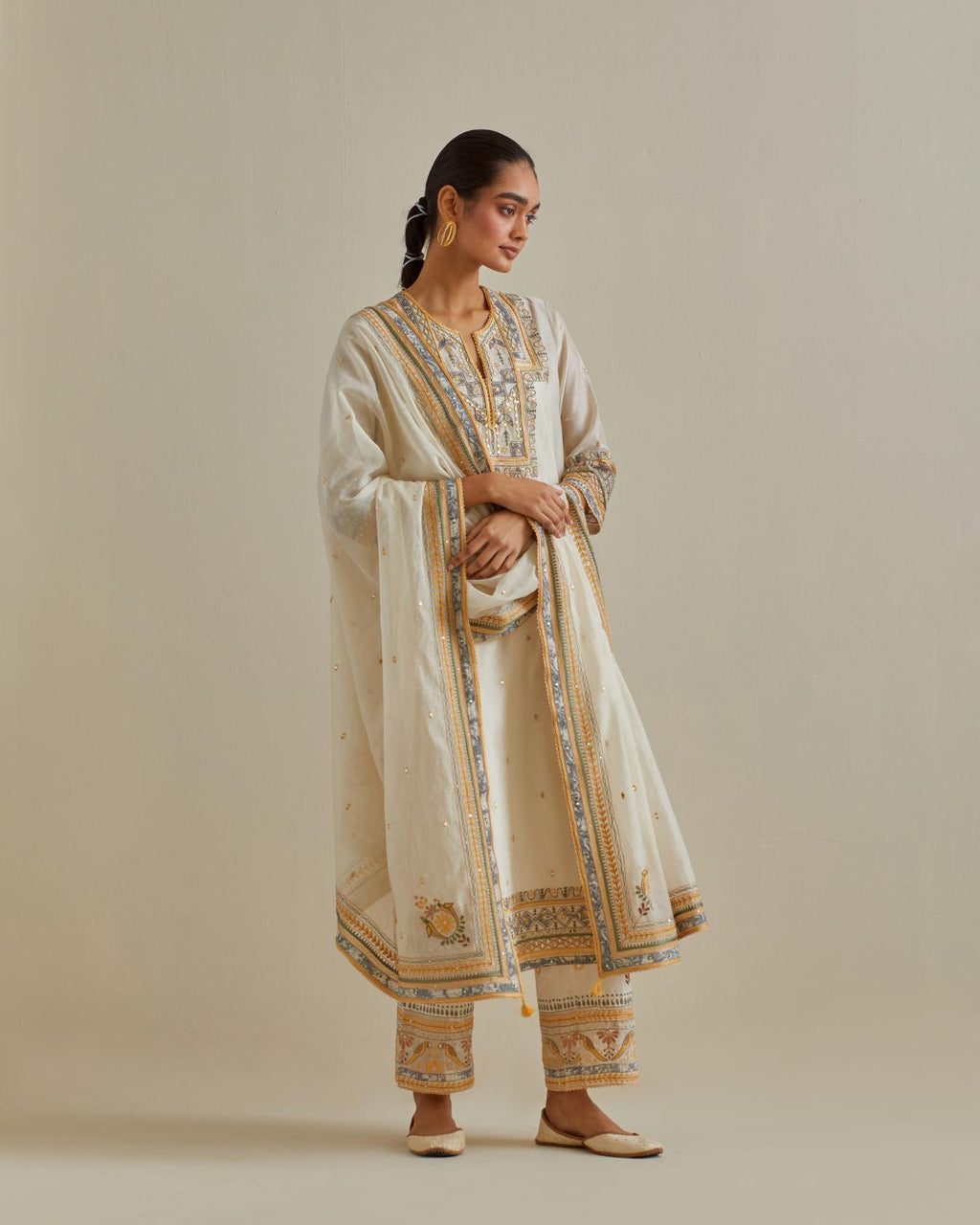 Yellow and off-white cotton chanderi straight kurta set with yoke with patchwork and silk thread embroidery highlighted with mirror, sequins, tassels and braids.