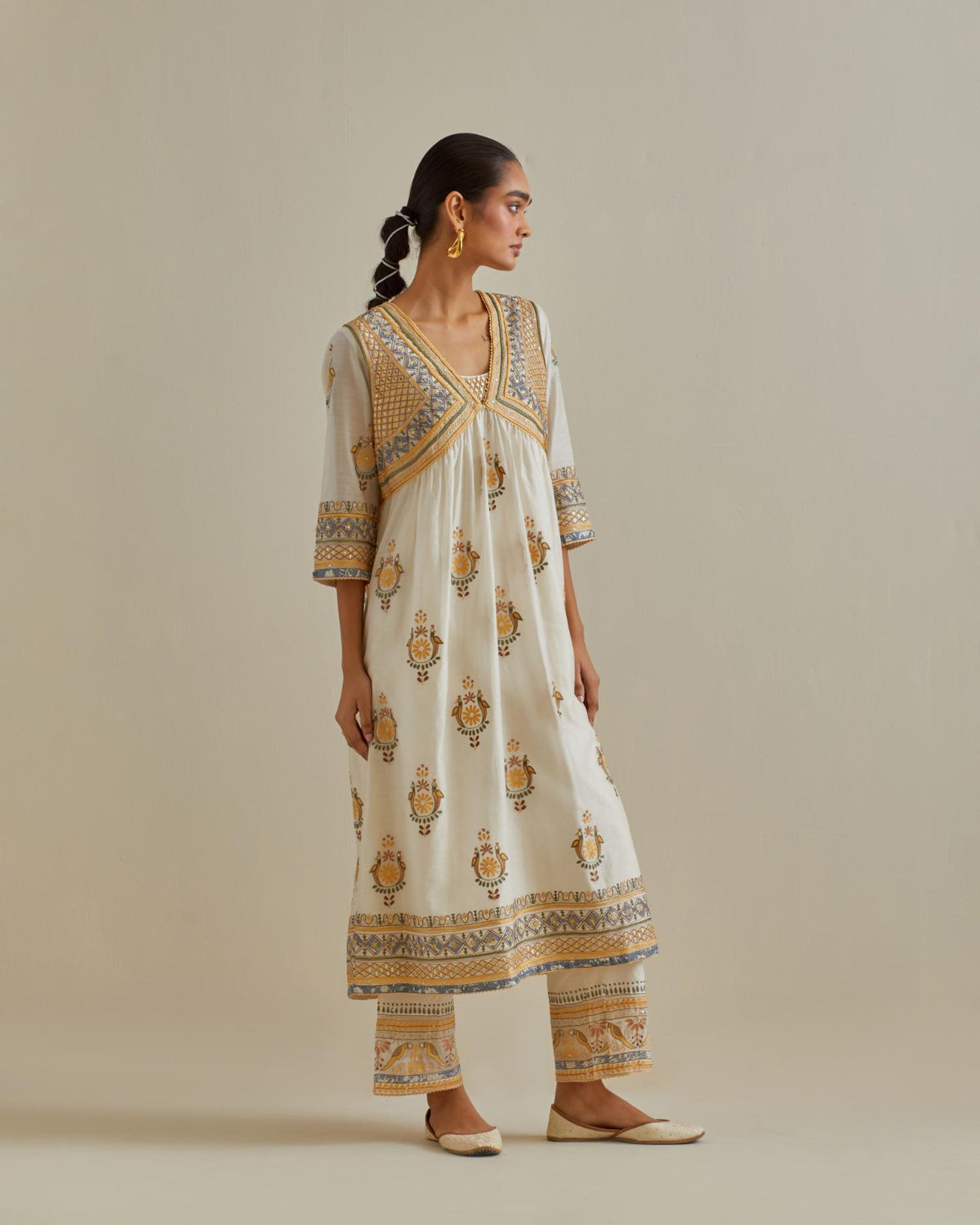 Yellow and off-white cotton chanderi embroidered kurta dress set with V neck, yoke and fine gathers at empire line.