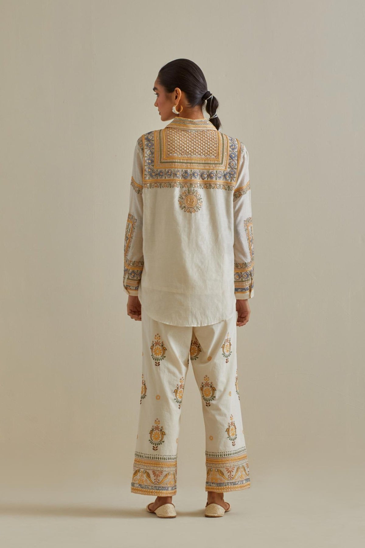 Yellow and off-white cotton chanderi embroidered shirt with full sleeves, paired with off white cotton straight pants with all over multi color embroidery detailed with sequins.