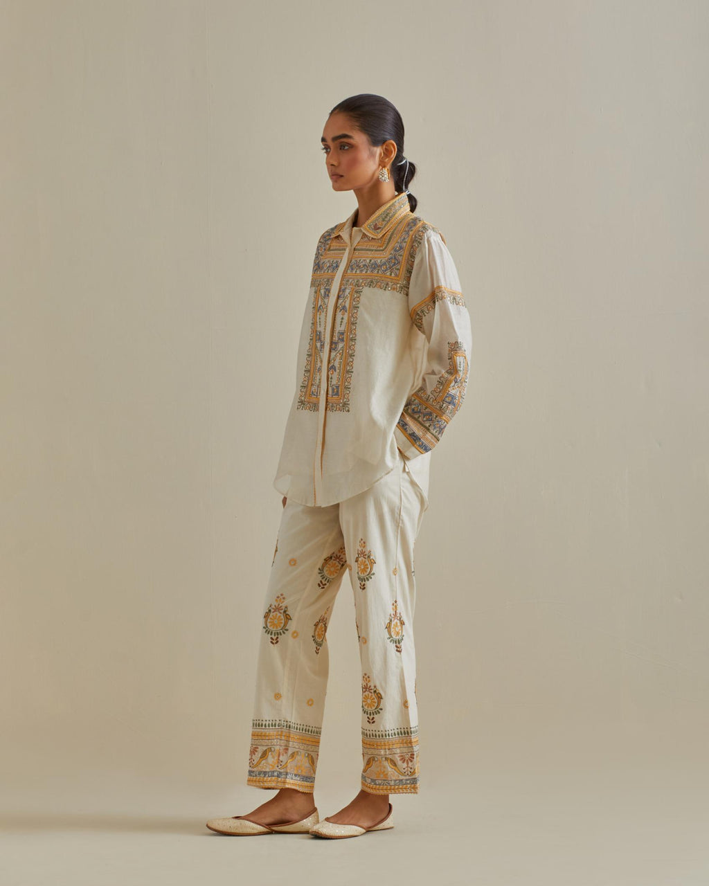 Yellow and off-white cotton chanderi embroidered shirt with full sleeves, paired with off white cotton straight pants with all over multi color embroidery detailed with sequins.
