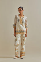 Yellow and off-white cotton chanderi embroidered short top with 3/4th sleeves, paired with off white cotton straight pants with all over multi color embroidery detailed with sequins.