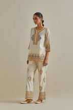 Yellow and off-white cotton chanderi embroidered short top with 3/4th sleeves, paired with off white cotton straight pants with all over multi color embroidery detailed with sequins.