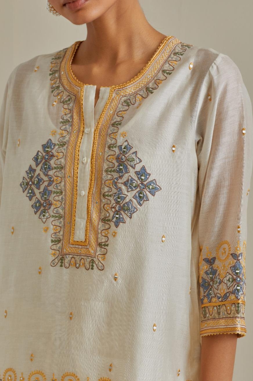 Yellow and off-white cotton chanderi embroidered short top with 3/4th sleeves, paired with off white cotton straight pants with all over multi color embroidery detailed with sequins.
