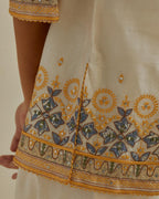 Yellow and off-white cotton chanderi embroidered short top with 3/4th sleeves, paired with off white cotton straight pants with all over multi color embroidery detailed with sequins.