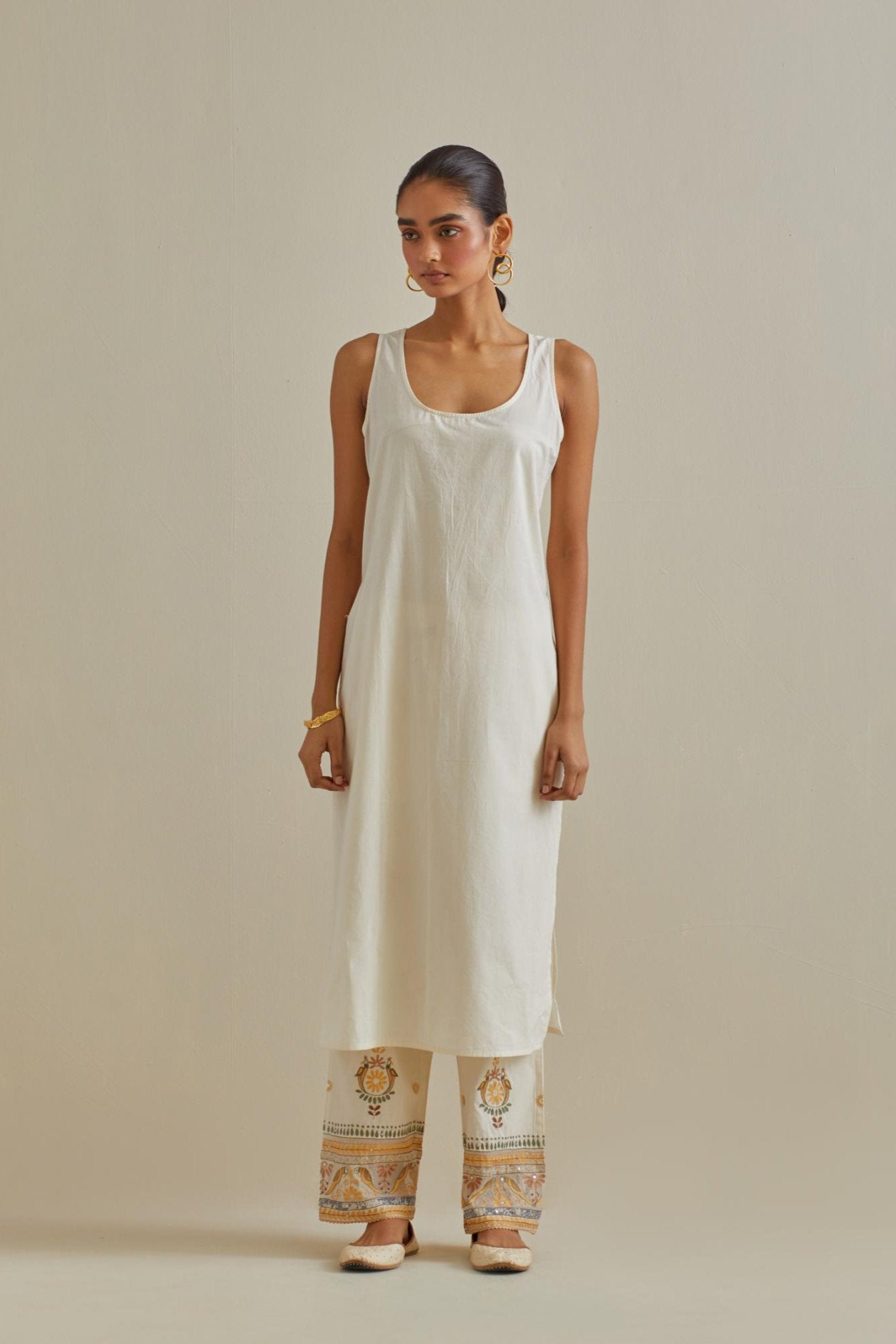 Yellow and off-white cotton chanderi easy fit long kaftan detailed with patch, silk thread, mirror & sequins work, paired with off white cotton straight pants with all over multi color embroidery detailed with sequins.