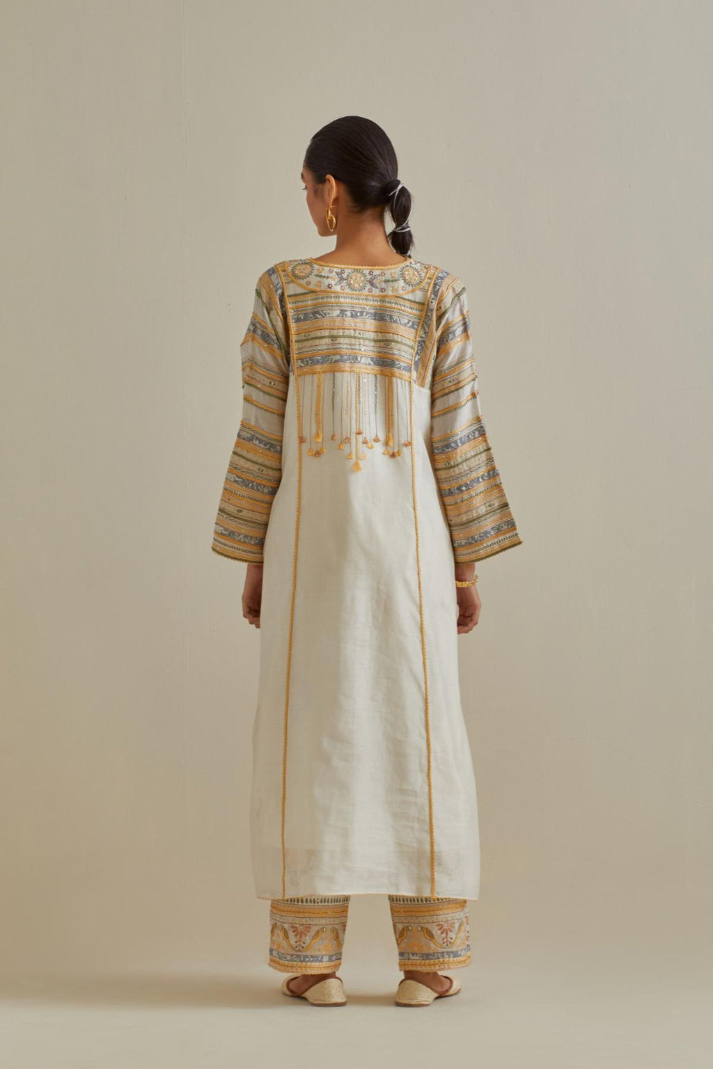 Yellow and off-white cotton chanderi easy fit long kaftan detailed with patch, silk thread, mirror & sequins work, paired with off white cotton straight pants with all over multi color embroidery detailed with sequins.