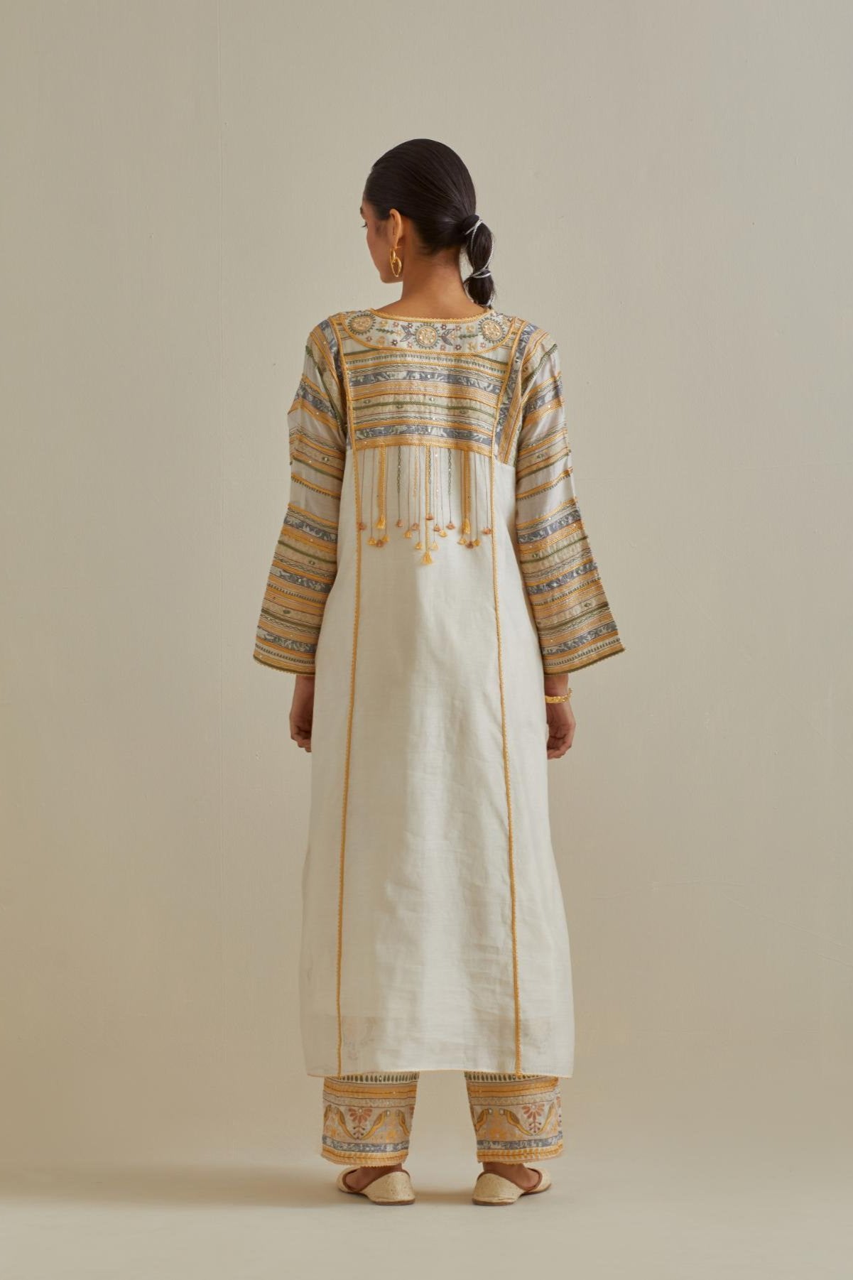 Yellow and off-white cotton chanderi easy fit long kaftan detailed with patch, silk thread, mirror & sequins work, paired with off white cotton straight pants with all over multi color embroidery detailed with sequins.