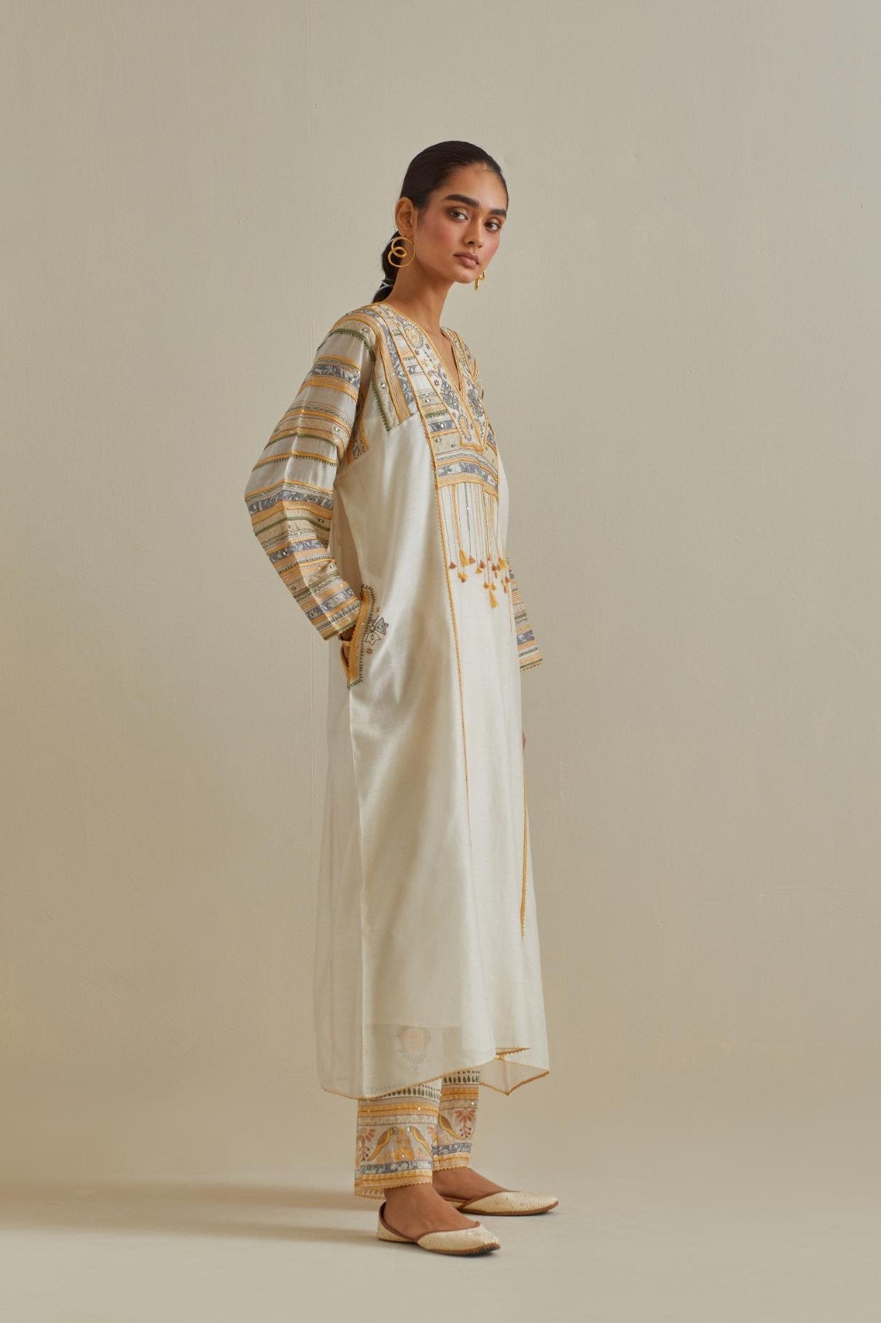 Yellow and off-white cotton chanderi easy fit long kaftan detailed with patch, silk thread, mirror & sequins work, paired with off white cotton straight pants with all over multi color embroidery detailed with sequins.