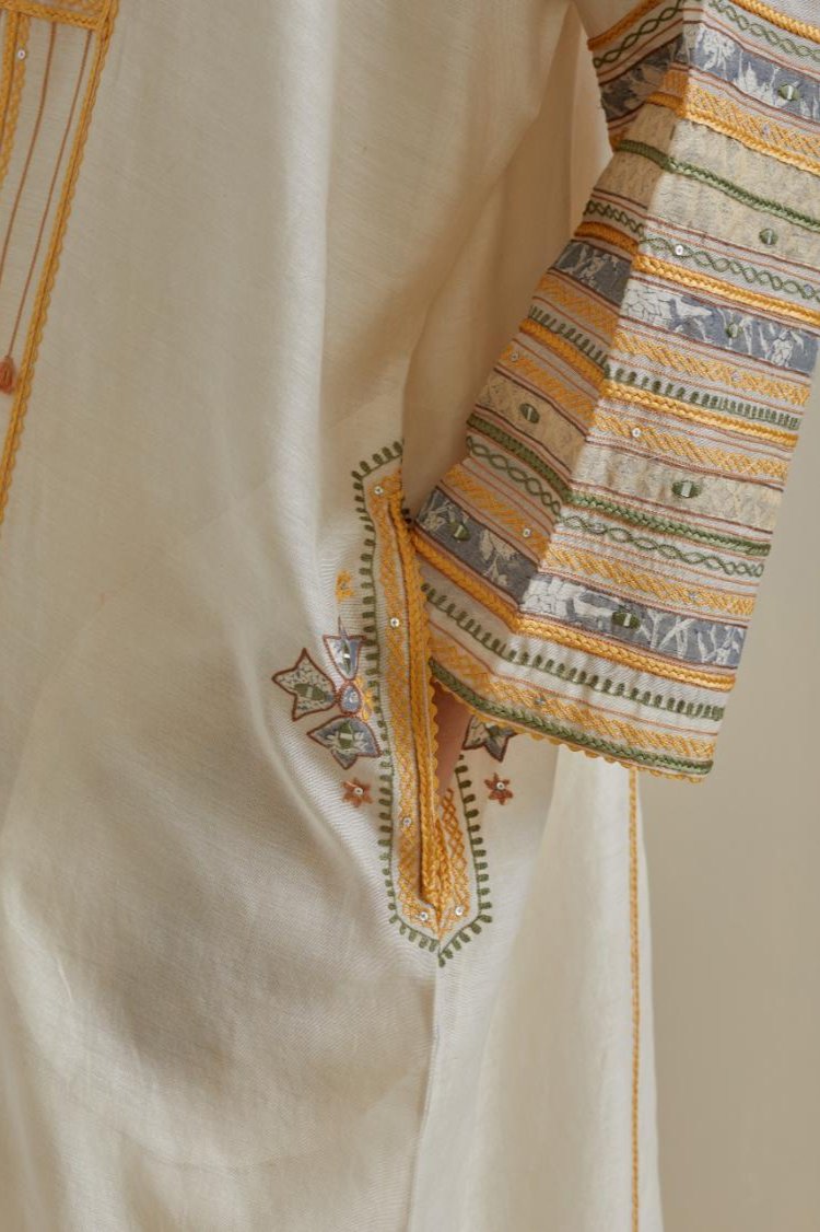 Yellow and off-white cotton chanderi easy fit long kaftan detailed with patch, silk thread, mirror & sequins work, paired with off white cotton straight pants with all over multi color embroidery detailed with sequins.