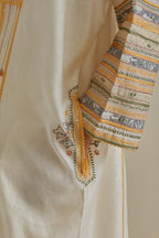 Yellow and off-white cotton chanderi easy fit long kaftan detailed with patch, silk thread, mirror & sequins work, paired with off white cotton straight pants with all over multi color embroidery detailed with sequins.